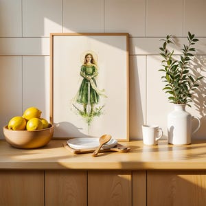 Op de afbeelding: Een ingelijste kunstdruk met een aquarelillustratie van een figuur in een groene jurk die een zwaard vasthoudt en rechtop staat. Het kunstwerk zit in een lichthouten lijst, naast een kom met gele citroenen en een witte vaas met groen.