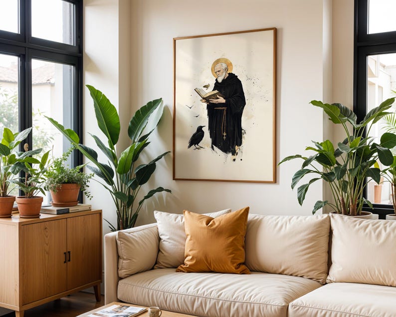 Peut inclure: Une impression d'art mural encadr&eacute;e repr&eacute;sentant un moine barbu en habit noir avec une aur&eacute;ole dor&eacute;e, lisant un livre ouvert. Un corbeau noir se tient pr&egrave;s de ses pieds et de petits oiseaux volent autour de lui sur un fond neutre avec des &eacute;claboussures.