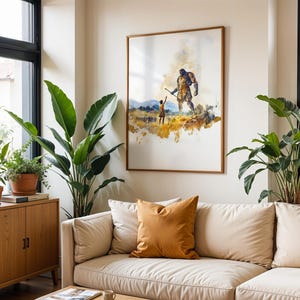 May include: A framed wall art print featuring a watercolour-style illustration of a small figure standing before a towering giant in a golden field. The artwork uses warm yellow, brown, and blue tones to depict a scene of scale and contrast.
