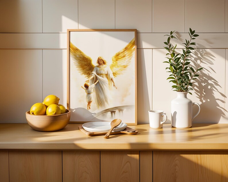 May include: A framed wall art print depicting an angel with large golden wings reaching down to hold the hand of a small child. The artwork is rendered in soft, light tones and is displayed in a simple wooden frame on a kitchen counter.