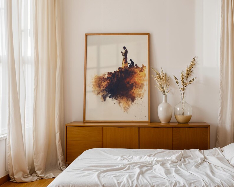 K&ouml;nnte beinhalten: Ein gerahmter rechteckiger Wandkunstdruck mit einer Illustration im Aquarellstil, die eine Figur auf einer Klippe in warmen Braun- und Oranget&ouml;nen zeigt. Das Kunstwerk befindet sich in einem hellen Holzrahmen auf einem Sideboard.