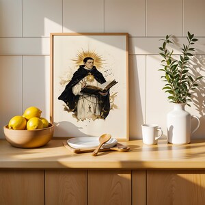 May include: A framed vertical art print featuring a religious figure in a black and white habit holding an open book, with a golden sunburst halo behind the head. The illustration is rendered in a watercolor style with sepia and ink tones.