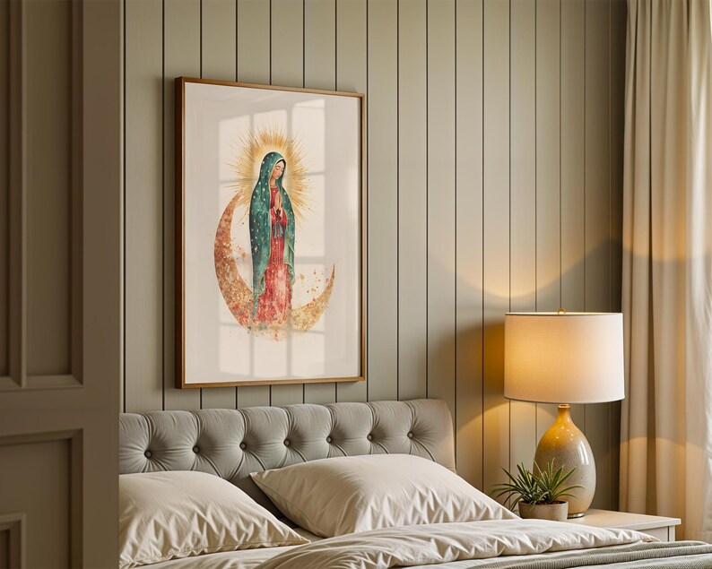 May include: A framed wall art print featuring a watercolor illustration of the Virgin of Guadalupe standing on a golden crescent moon, surrounded by a radiant sunburst halo, with a teal mantle and a red dress, displayed in a wooden frame.