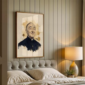 May include: A framed wall art print featuring a watercolor-style portrait of an elderly person with a bald head, wearing a dark clerical shirt with a white collar, set against a cream background with gold-toned paint splatters and drips.