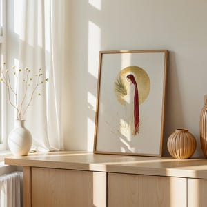 Puede incluir: Una l&aacute;mina enmarcada que muestra una figura con t&uacute;nica blanca y capa roja sosteniendo una palma frente a un gran halo circular dorado. La ilustraci&oacute;n se encuentra en una habitaci&oacute;n clara con un jarr&oacute;n blanco y dos jarrones de madera.