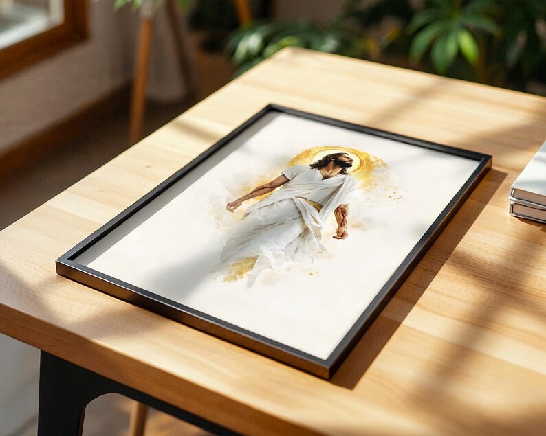 Puede incluir: Una impresi&oacute;n enmarcada que presenta una ilustraci&oacute;n estilo acuarela de una figura con cabello largo casta&ntilde;o y barba, vistiendo t&uacute;nicas blancas fluidas. Un halo circular dorado rodea la cabeza, con salpicaduras de pintura amarilla y dorada.