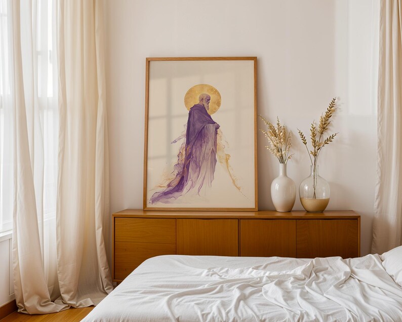 May include: A framed vertical wall art print featuring a watercolour-style illustration of a figure in a flowing purple robe with a golden circular halo behind the head, set against a light cream background within a simple light wood frame.