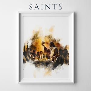 May include: A framed wall art print titled SAINTS featuring a watercolour-style illustration of a group of people gathered around a table with a central figure holding a chalice, rendered in warm amber, brown, and dark tones on a white background.