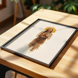 Puede incluir: Una l&aacute;mina art&iacute;stica enmarcada con una ilustraci&oacute;n estilo acuarela de una persona con las manos juntas en oraci&oacute;n, vistiendo una prenda clara con una faja marr&oacute;n y un collar de cruz, sobre un fondo crema con un halo dorado de rayos solares.