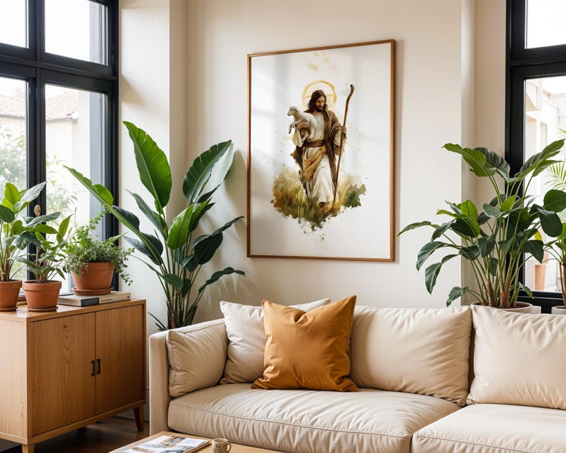 May include: A framed wall art print featuring a watercolour-style illustration of a figure with long brown hair and a beard, wearing robes, holding a small white lamb in one arm and a wooden staff in the other, set against a white background.
