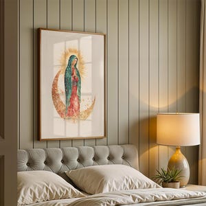 Puede incluir: Una impresi&oacute;n de arte mural enmarcada que muestra a la Virgen de Guadalupe de pie sobre una luna creciente. La figura viste un manto color verde azulado y un vestido rojo, rodeada por un halo de sol dorado sobre un fondo claro en un marco de madera.
