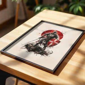 May include: A framed art print featuring a dark, ink-style illustration of a knight in armour standing over a defeated creature. The knight holds a sword and a shield with a red cross, set against a bold red circular background on a cream paper.