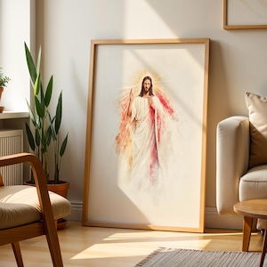 May include: A framed wall art print featuring a watercolor-style illustration of a figure with long brown hair and a beard, wearing white robes with red accents, depicted with a glowing golden halo and rays of light emanating from behind.