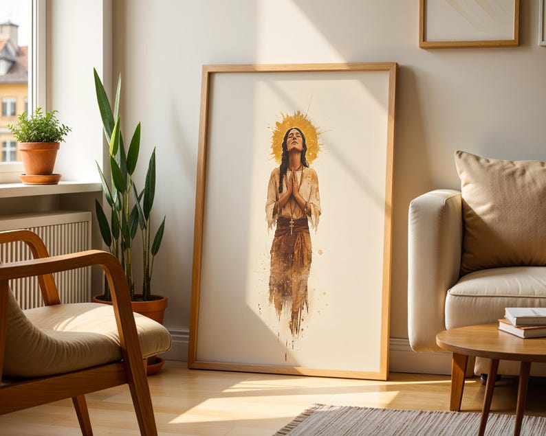May include: A framed vertical wall art print featuring a watercolour-style illustration of a person with eyes closed and hands pressed together in prayer. The figure is centred with a golden halo behind the head, wearing earth-toned clothing.