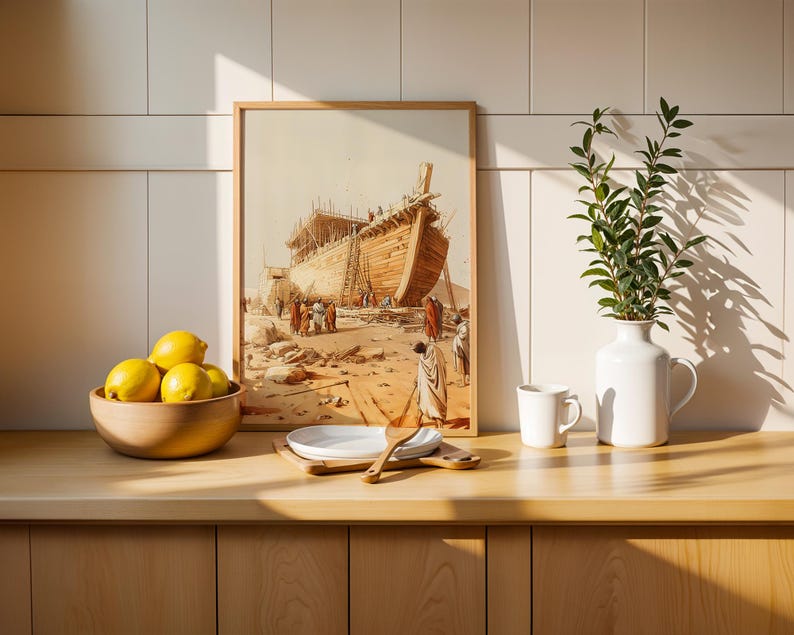 May include: A framed print depicting a large wooden ship under construction in a desert landscape, displayed next to a wooden bowl of yellow lemons, a stack of white plates with a wooden spoon, a white mug, and a white vase with green leaves.