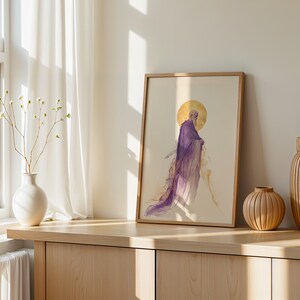 May include: A framed vertical art print featuring a watercolour-style illustration of a bearded figure in a flowing purple robe with a golden halo behind the head, set against a light cream background within a simple light wood frame.