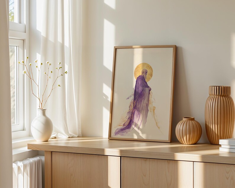 May include: A framed vertical art print featuring a watercolour-style illustration of a bearded figure in a flowing purple robe with a golden halo behind the head, set against a light cream background within a simple light wood frame.