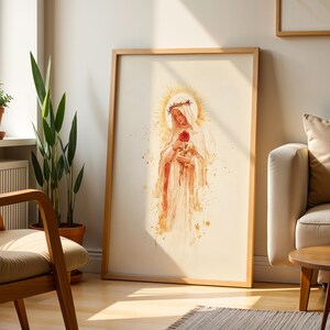 May include: A framed vertical wall art print featuring a watercolor-style illustration of a figure wearing a crown of thorns and a white veil, holding a single red rose. The artwork is rendered in soft beige, gold, and red tones with a halo.