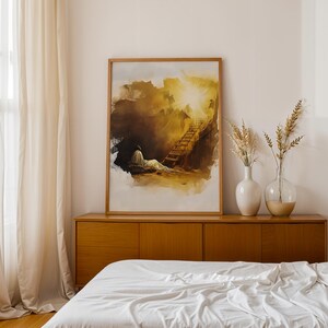 Op de afbeelding: Een rechthoekige wandkunstprint in een lichthouten lijst met een abstract aquarel van een figuur die rust bij een trap die naar een fel licht leidt, uitgevoerd in tinten goudgeel, bruin en wit op een witte achtergrond.