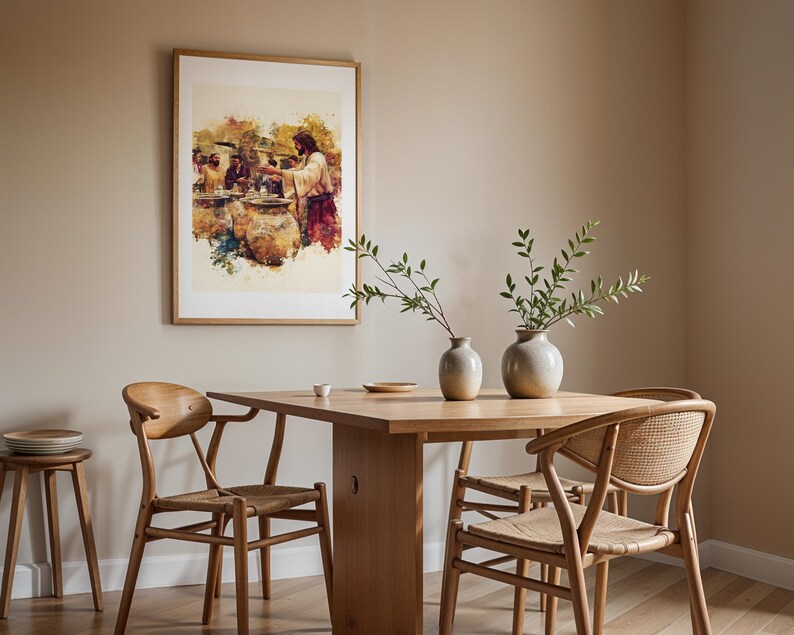 May include: A framed watercolor-style print depicting a biblical scene with figures and large clay jars hanging on a wall above a wooden dining table. The table features two ceramic vases with green branches, surrounded by four wooden chairs.