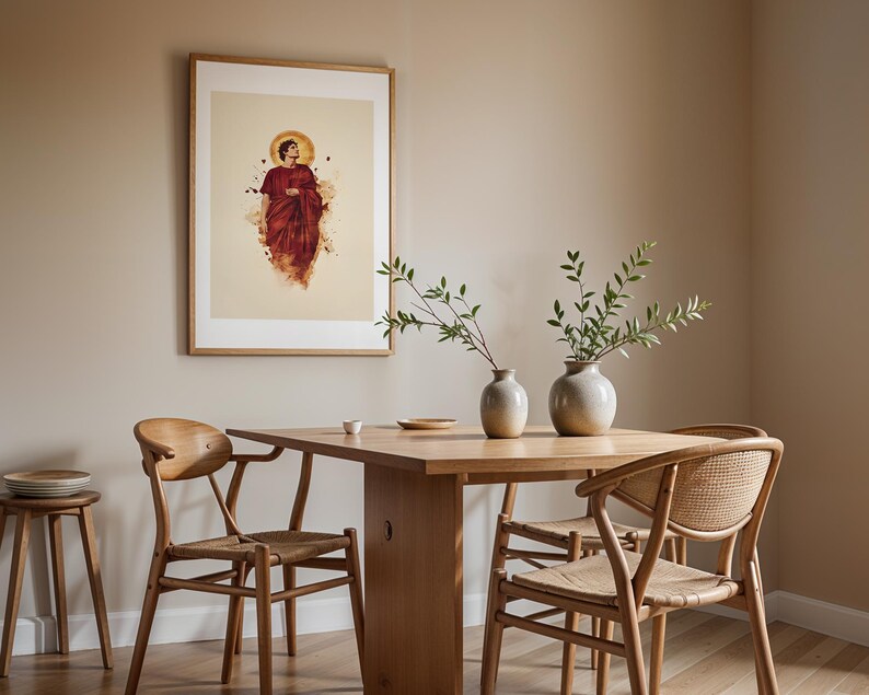 May include: A framed wall art print featuring a figure in a dark red robe with a golden halo, displayed above a wooden dining table with two light-coloured ceramic vases containing green leafy branches and three wooden chairs with woven seats.