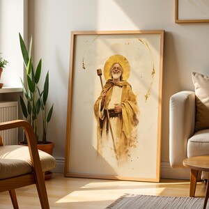 Puede incluir: Una impresi&oacute;n de arte mural vertical enmarcada que presenta una ilustraci&oacute;n estilo acuarela de una figura barbuda sonriente con un halo dorado, vistiendo t&uacute;nicas color canela y sosteniendo un bast&oacute;n de madera sobre un fondo crema con detalles dorados.