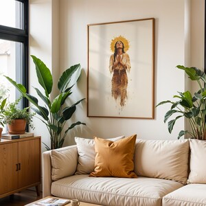 Puede incluir: Una impresi&oacute;n de arte mural enmarcada que muestra a una persona con cabello largo y oscuro en posici&oacute;n de oraci&oacute;n con las manos juntas, rodeada por un efecto de halo dorado. La ilustraci&oacute;n usa tonos tierra marrones y beige con estilo acuarela.