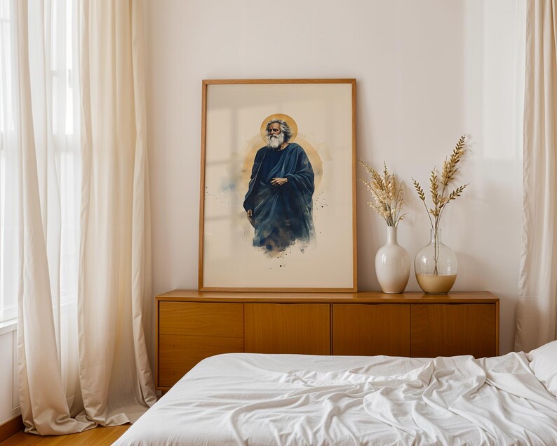May include: A framed vertical wall art print featuring a watercolor-style illustration of a bearded figure with long hair wearing a dark blue robe, set against a soft beige background with a circular golden halo behind the figure's head.