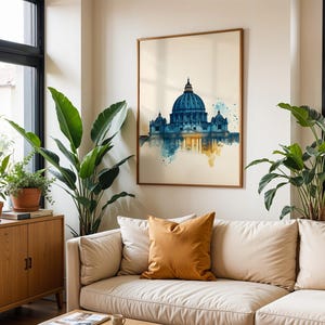 May include: A framed wall art print featuring a watercolour-style illustration of St. Peter's Basilica in Rome. The artwork displays a deep blue dome and architectural details, transitioning into soft yellow and teal paint splatters at the base.