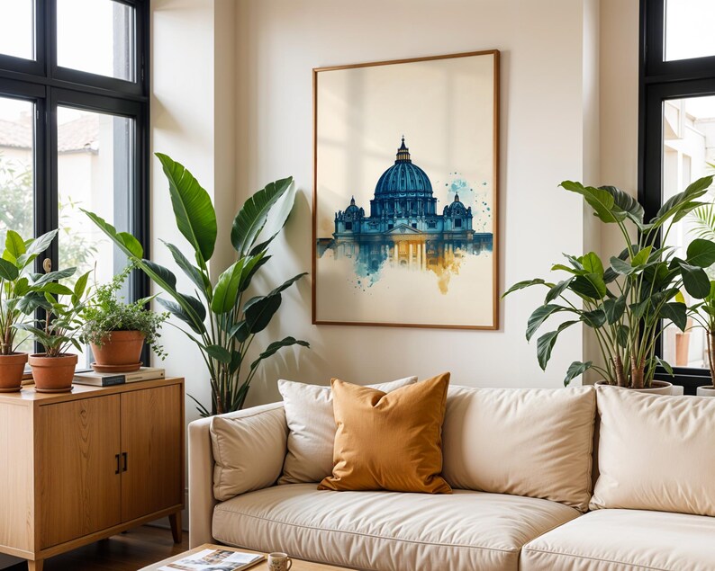 May include: A framed wall art print featuring a watercolour-style illustration of St. Peter's Basilica in Rome. The artwork displays a deep blue dome and architectural details, transitioning into soft yellow and teal paint splatters at the base.