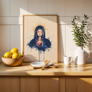 May include: A framed wall art print featuring a watercolor-style illustration of a figure in a dark blue hooded cloak with a glowing red heart at the center, surrounded by a golden halo effect against a light beige background.