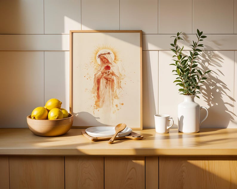 K&ouml;nnte beinhalten: Ein gerahmter vertikaler Kunstdruck mit einer Aquarellillustration einer Figur, die eine Dornenkrone tr&auml;gt und eine rote Rose h&auml;lt, umgeben von einem goldenen Heiligenschein. Der Druck steht neben einer Holzschale mit gelben Zitronen und einer wei&szlig;en Vase.