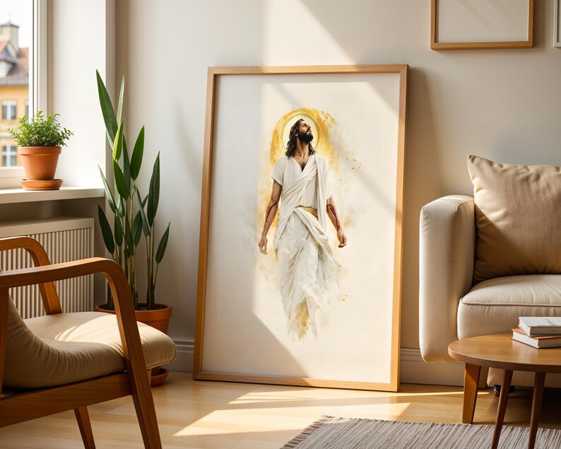 May include: A framed vertical wall art print featuring a watercolor-style illustration of a figure with long hair and a beard, wearing white robes, looking upward with a golden halo effect behind the head, set against a light cream background.