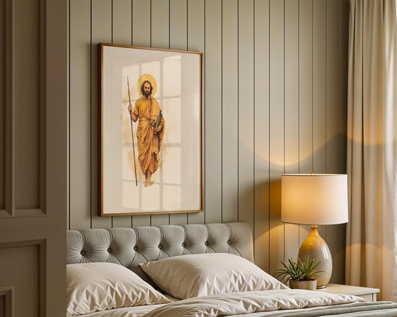 K&ouml;nnte beinhalten: Ein gerahmter Kunstdruck mit einer Aquarell-Illustration einer b&auml;rtigen Figur in goldenen Gew&auml;ndern, die einen langen Stab und ein Buch h&auml;lt, mit einem kreisf&ouml;rmigen Heiligenschein hinter dem Kopf, in einem hellen Holzrahmen an einer Wand.