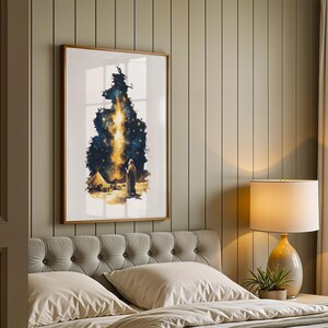 May include: A framed vertical wall art print featuring a dark blue and gold celestial scene with a bright vertical light beam, a small tent, and a solitary figure standing on a sandy landscape under a starry night sky.