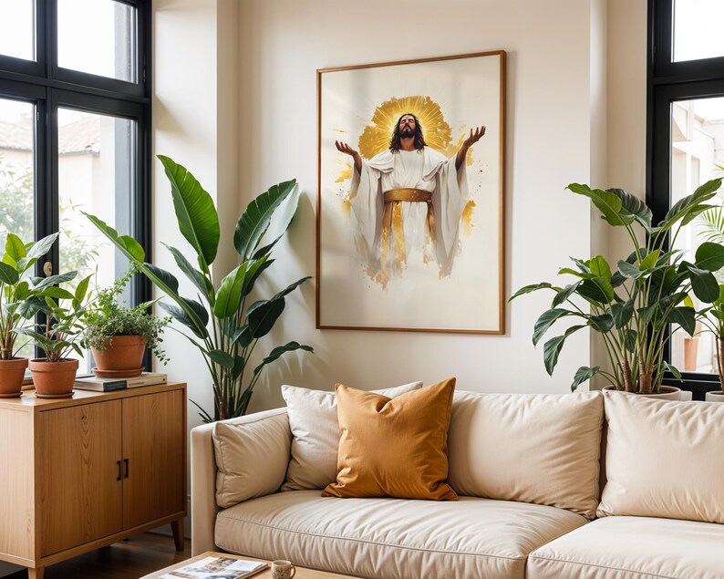 May include: A framed wall art print featuring a central figure with long dark hair and a beard, wearing a white robe with a gold sash, arms raised upwards, set against a radiant gold sunburst background, displayed in a light-coloured room.