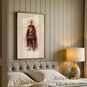 Puede incluir: Una l&aacute;mina de arte enmarcada que presenta una ilustraci&oacute;n en acuarela de una figura con armadura de estilo romano antiguo y una capa roja larga, de pie con una espada. La obra est&aacute; expuesta en un marco de madera sobre una pared panelada.