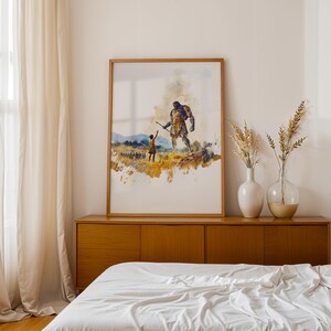 May include: A framed watercolour print depicting a small figure reaching towards a large, towering giant in a golden field. The artwork features muted tones of yellow, blue, and brown, showcasing a dramatic scene of scale and interaction.