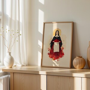 Pu&ograve; includere: Una stampa artistica incorniciata con l'illustrazione centrale di una figura che indossa un mantello nero e una gonna rossa, che tiene un panno bianco pieno di rose rosse. La figura ha un'aureola dorata dietro la testa e una collana con croce.