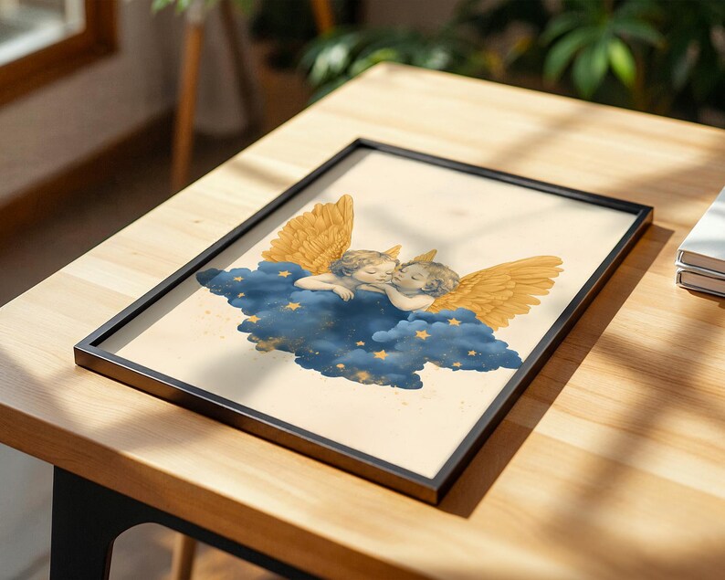 May include: A framed print featuring two cherubs with golden wings resting on a dark blue cloud decorated with small yellow stars. The illustration is set against a cream-coloured background, enclosed within a thin black rectangular frame.