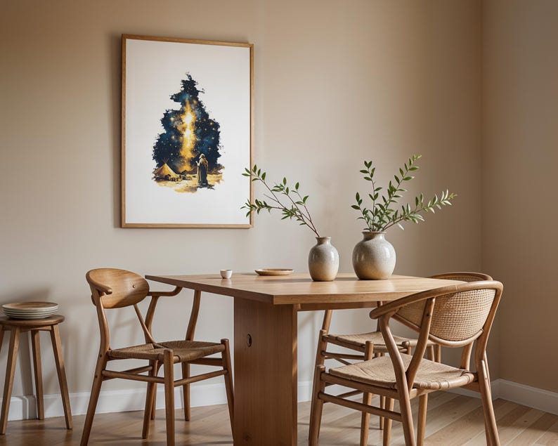 May include: A framed wall art print featuring a dark blue and gold starry night sky illustration with a figure standing near a tent. The artwork is displayed in a room with a wooden dining table, four wooden chairs with woven seats, and two ceramic vases.