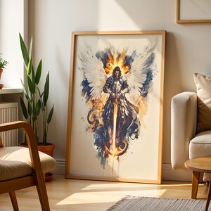 May include: A framed vertical wall art print featuring a watercolour-style illustration of a winged warrior in silver armour holding a glowing golden sword. The figure is surrounded by white wings, dark blue splashes, and bright orange light accents.