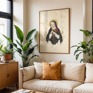 Puede incluir: Una l&aacute;mina de arte mural enmarcada con una ilustraci&oacute;n digital de una monja con h&aacute;bito negro y velo blanco, sosteniendo una cruz de madera y una rosa roja. La figura tiene un halo dorado sobre un fondo de color crema claro.