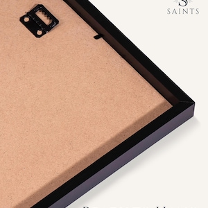 May include: A black rectangular picture frame shown from the back, featuring a light brown fiberboard backing and a black metal sawtooth hanger. The text SAINTS is visible in the top right corner, and the text READY TO HANG is at the bottom.