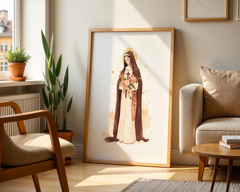 May include: A framed wall art print featuring a watercolor illustration of a figure in a brown habit and white robe, holding a bouquet of pink and white roses with a small cross. The figure has a golden halo and stands against a light background.