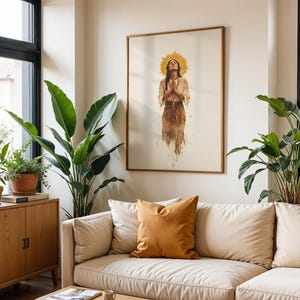May include: A framed wall art print featuring a centred illustration of a person with long dark hair, eyes closed, and hands pressed together in prayer. The figure is surrounded by a golden halo effect against a cream background.