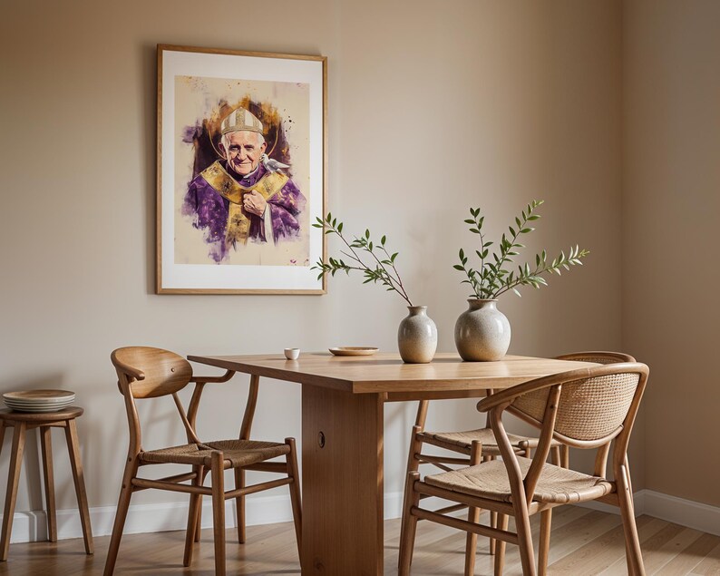 K&ouml;nnte beinhalten: Ein gerahmtes Portr&auml;t von Papst Benedikt XVI. mit wei&szlig;er Mitra und violettem Messgewand mit Goldstickerei, das an einer Wand &uuml;ber einem h&ouml;lzernen Esstisch mit zwei Keramikvasen mit gr&uuml;nen Zweigen und Holzst&uuml;hlen h&auml;ngt.