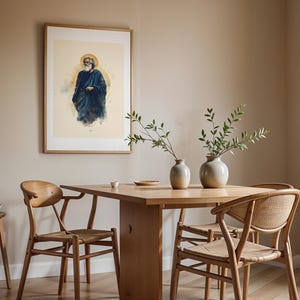 May include: A framed wall art print featuring a bearded figure in a dark blue robe with a golden halo, displayed above a wooden dining table with two ceramic vases containing green branches and three wooden chairs with woven seats.