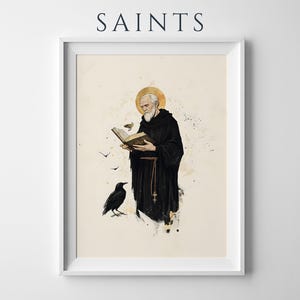 Op de afbeelding: Een ingelijste kunstdruk getiteld SAINTS met een bebaarde monnik in een zwart habijt met een gouden aureool, lezend in een open boek. Een zwarte raaf staat in de buurt en kleine vogels vliegen rond de figuur. Inktwas-stijl details.