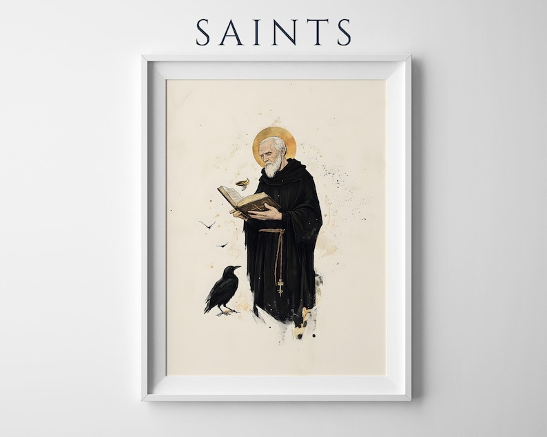 Op de afbeelding: Een ingelijste kunstdruk getiteld SAINTS met een bebaarde monnik in een zwart habijt met een gouden aureool, lezend in een open boek. Een zwarte raaf staat in de buurt en kleine vogels vliegen rond de figuur. Inktwas-stijl details.